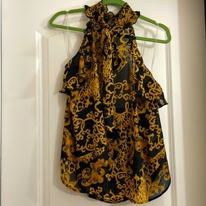 Sleeveless black, brown gold blouse with ruffles around arms and open in back.